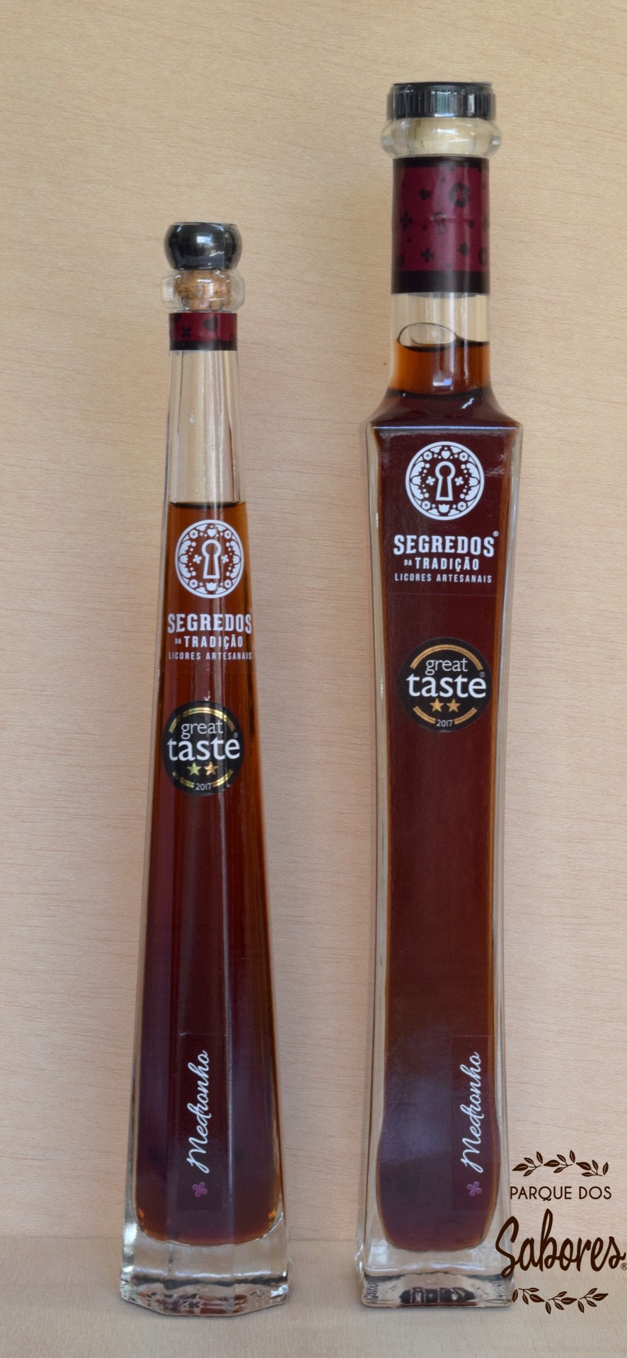 Duas garrafas de licor artesanal com rótulo Segredos da Tradição e selo great taste