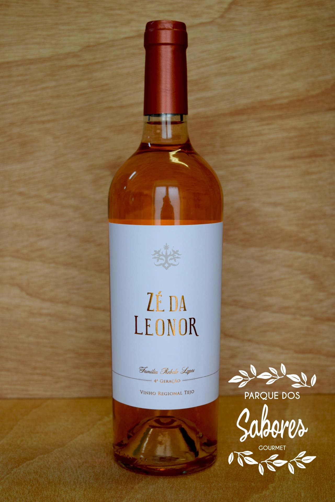 Garrafa de vinho rosé com rótulo branco e texto dourado e preto