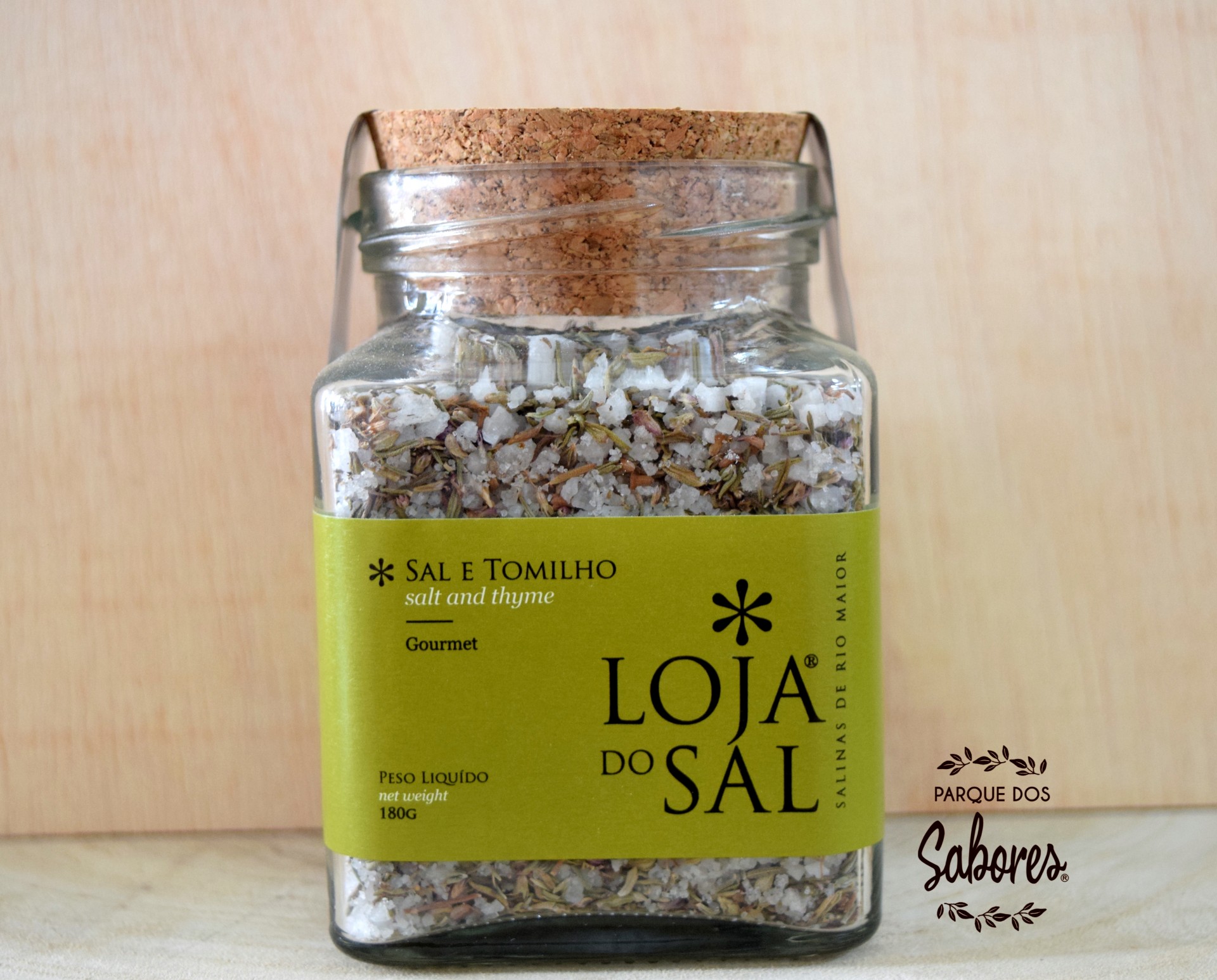 Frasco de vidro com sal e tomilho e etiqueta verde