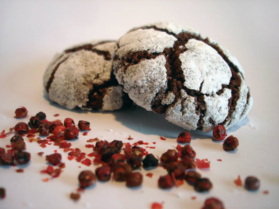 Biscoitos de chocolate rachados com pimenta rosa sobre superfície branca