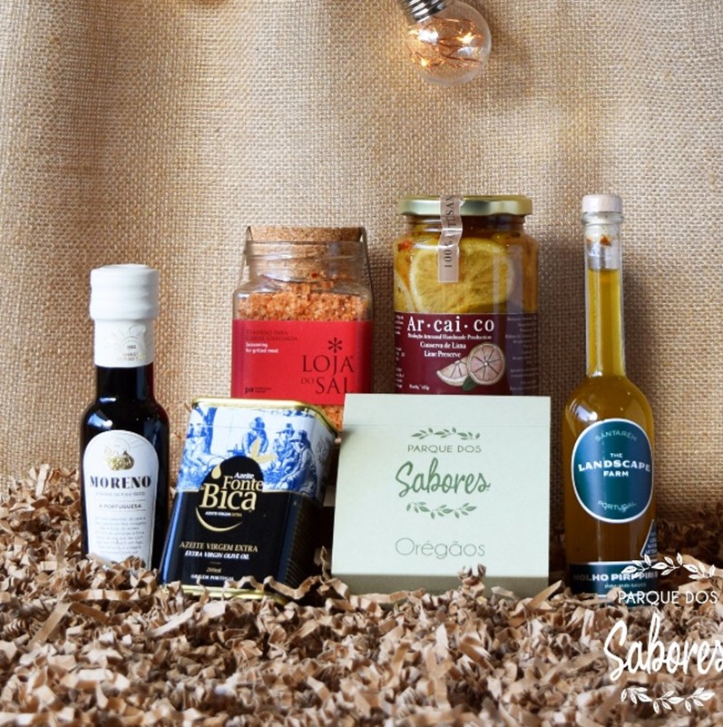 Produtos gourmet com azeite, sal temperado, pimentos com limão e orégãos em embalagem decorativa