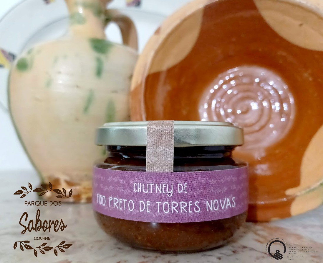 Frasco de chutney de figo preto com jarro e prato cerâmico ao fundo