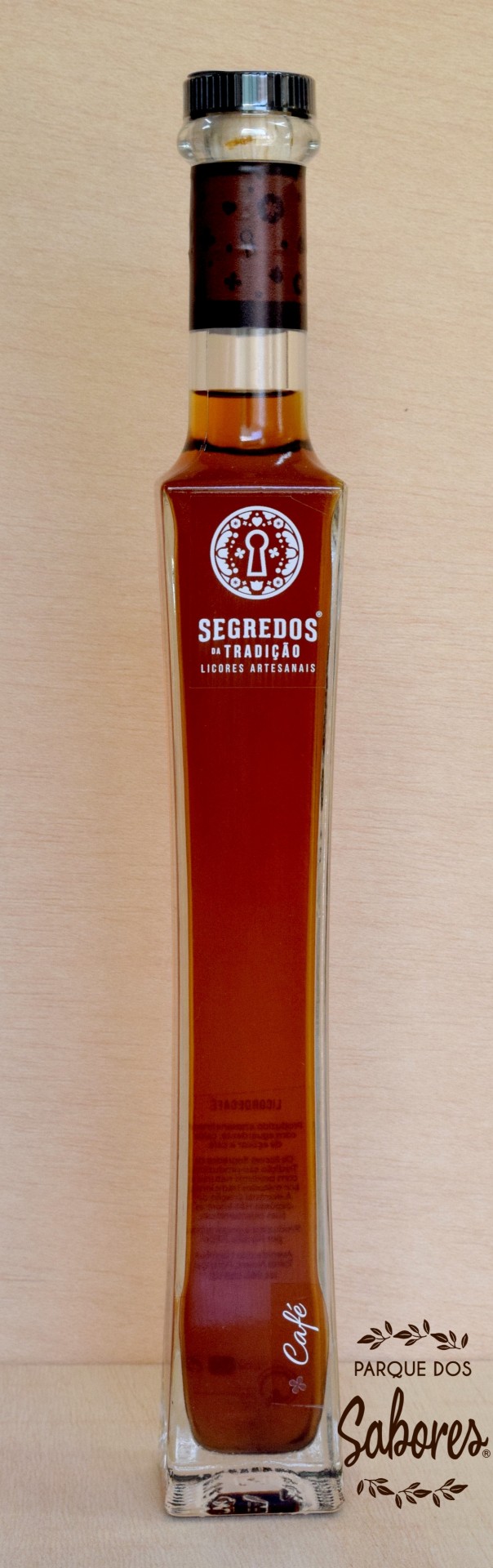 Licor de Café Garrafa longa de vidro com licor castanho e rótulo branco com texto e tampa preta