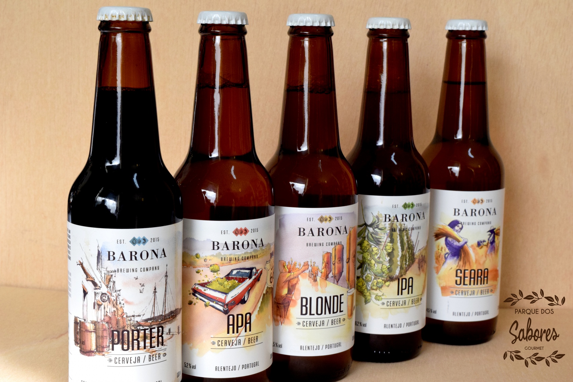 Cinco garrafas de cerveja Barona com rótulos coloridos diferentes alinhadas