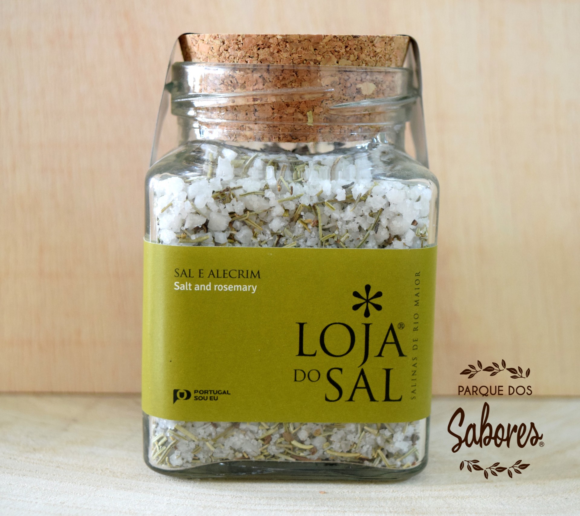 Frasco de vidro com sal e alecrim com rótulo verde-oliva e tampa de cortiça.