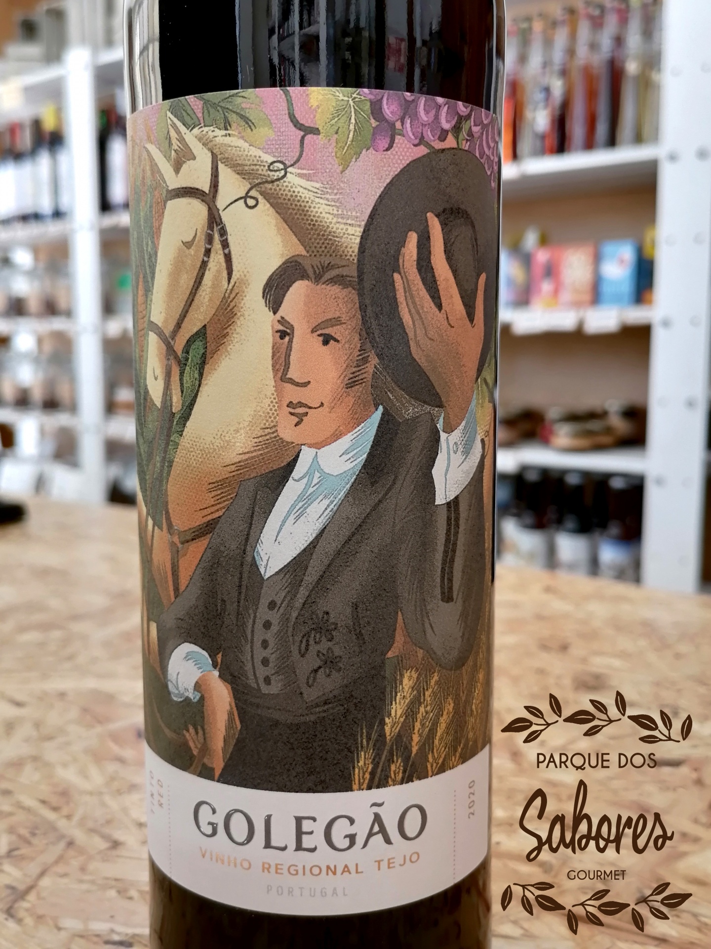 Garrafa de vinho tinto com rótulo ilustrado de homem e cavalo e texto Parque dos Sabores
