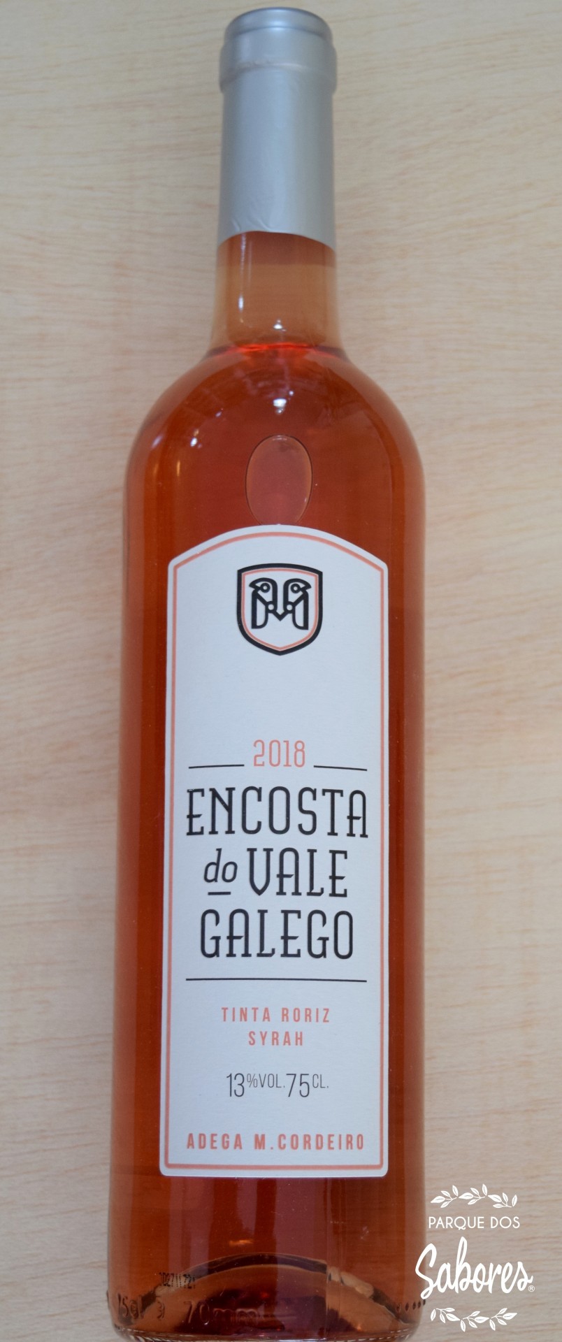 Garrafa de vinho rosé Encosta do Vale Galego com rótulo branco sobre superfície de madeira clara