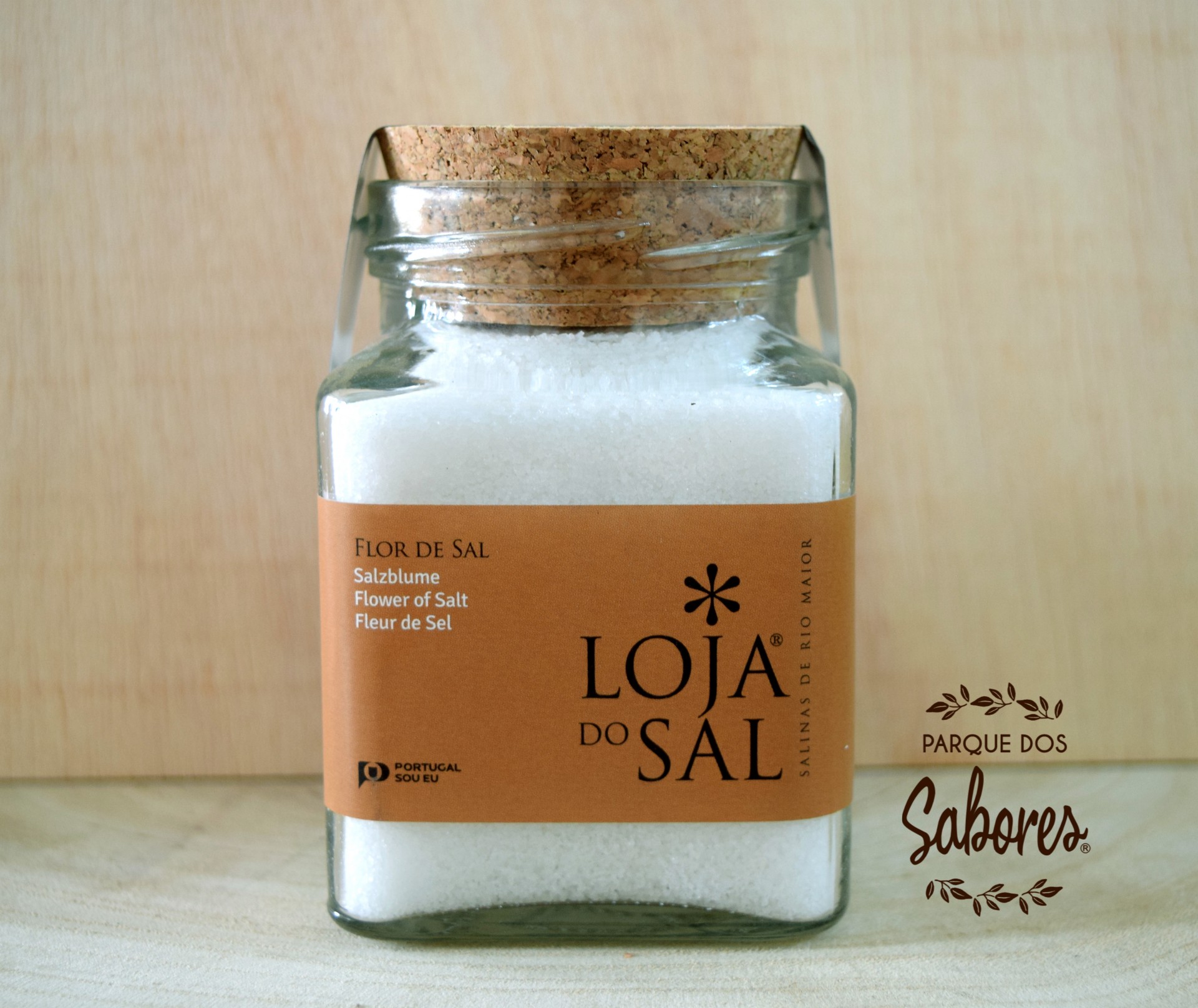 Frasco quadrado de vidro com tampo de cortiça contendo flor de sal e rótulo laranja
