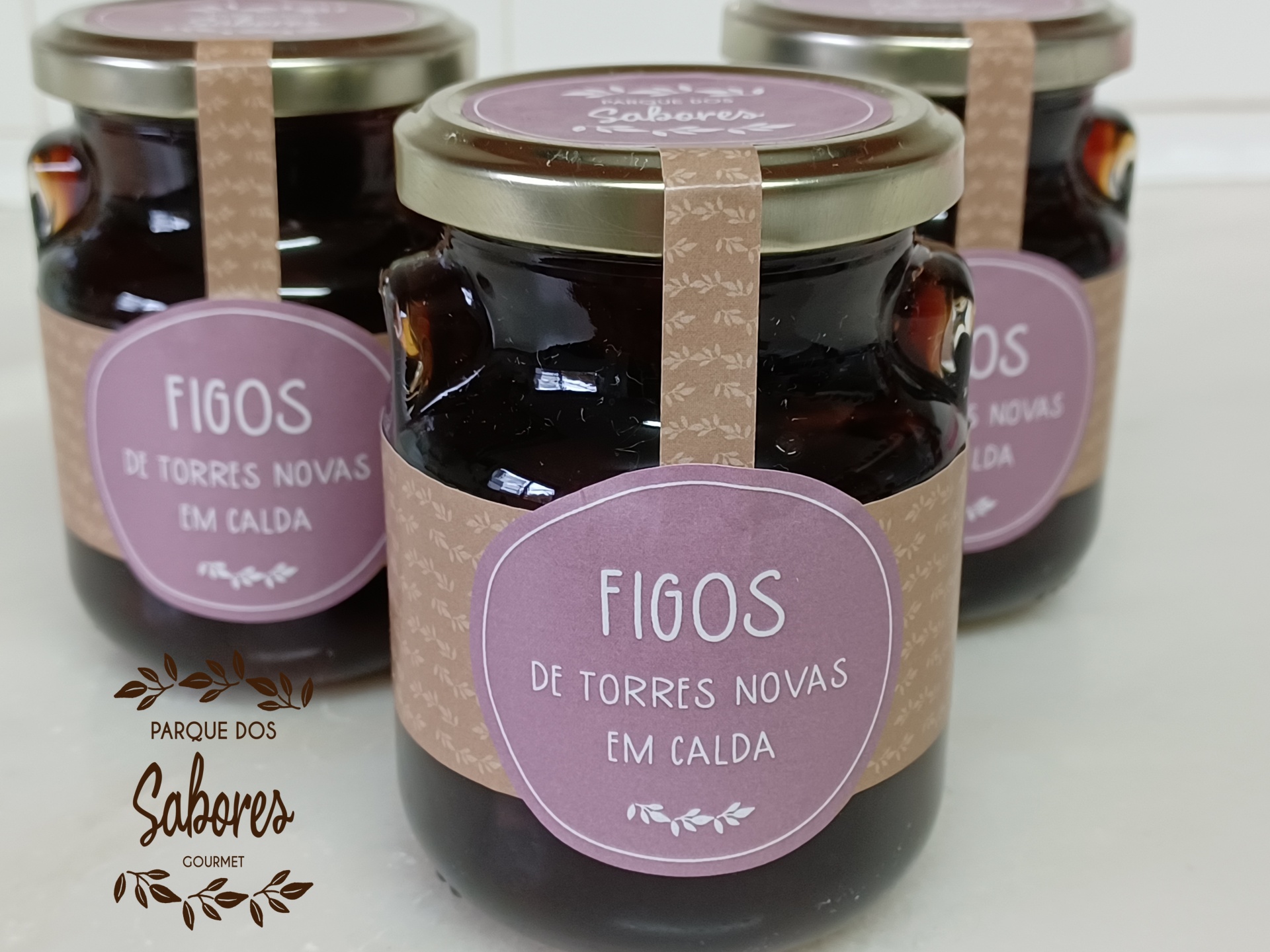 Três frascos de vidro com figos em calda e rótulos rosa