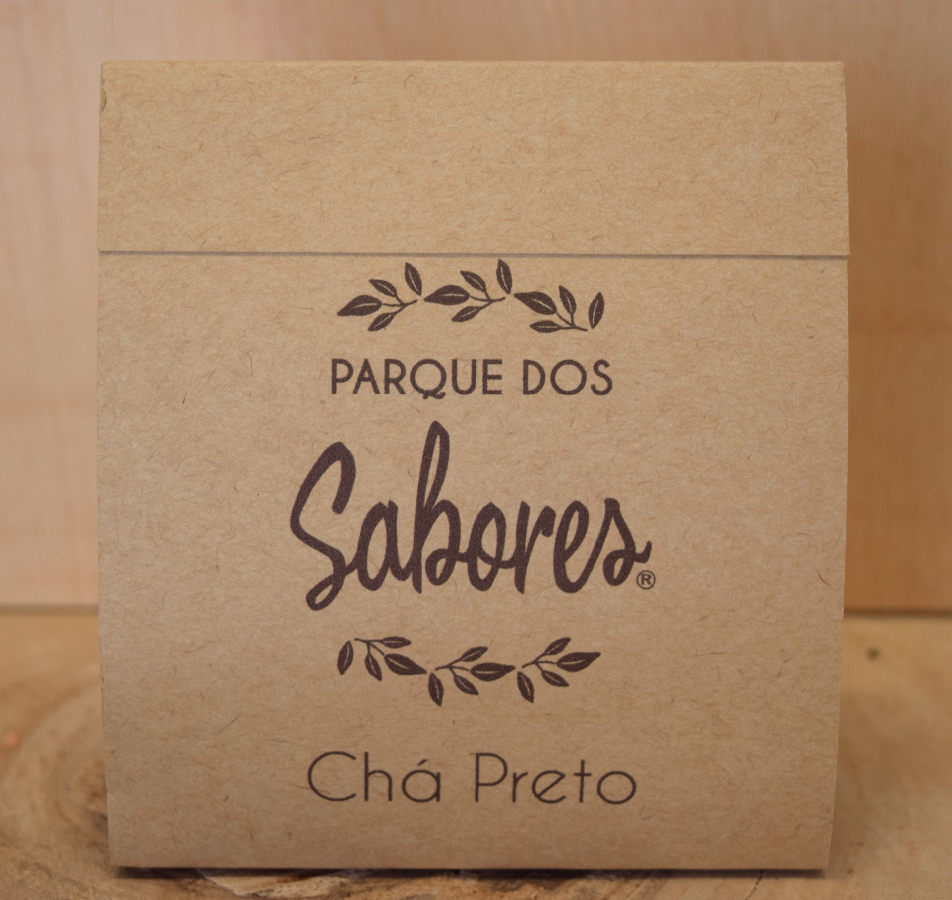 Pacote de chá preto Parque Dos Sabores em papel castanho com texto e folhas desenhadas