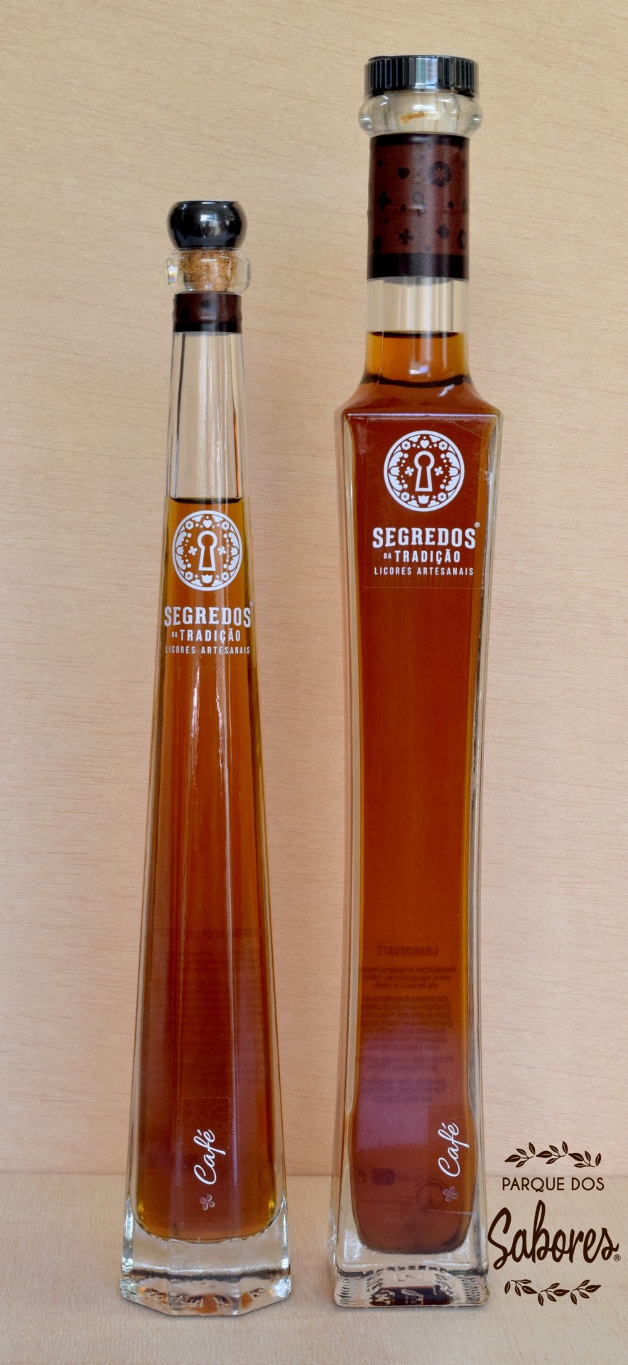 Duas garrafas de licor artesanal de café em vidro alto e fino com rótulos brancos