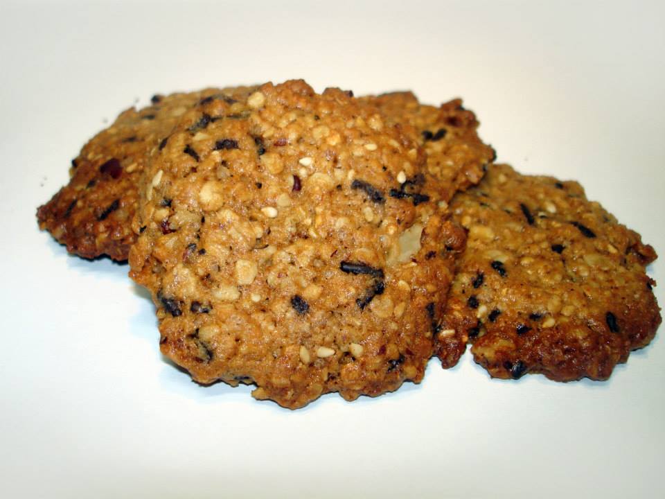 Três bolachas de aveia com sementes sobre superfície branca