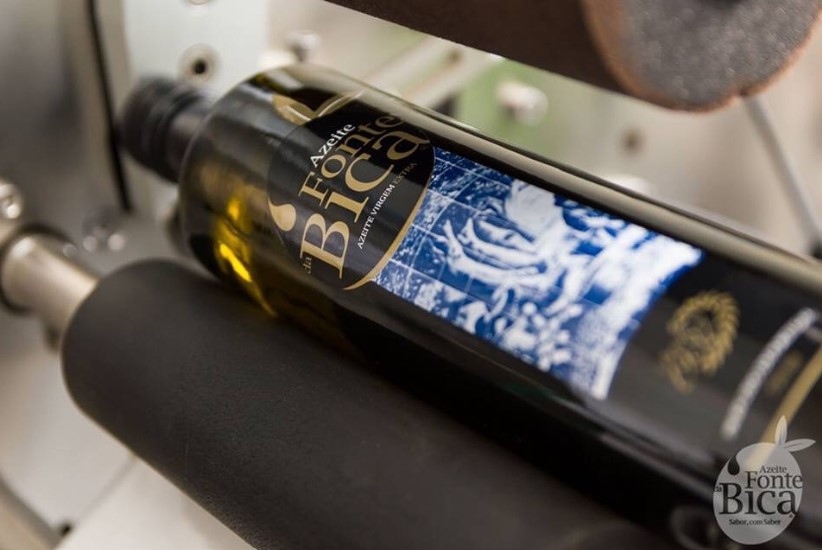 Garrafa de vidro verde escuro com rótulo preto e azul