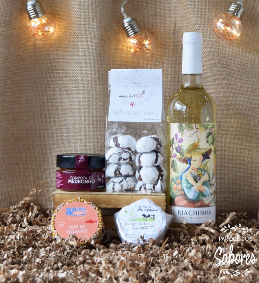 Conjunto gourmet com vinho branco, bolachas de noz, compota de medronho, paté de salmão e queijo sobre fundo de juta com luzes decorativas.