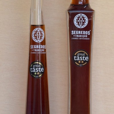 Duas garrafas de licor artesanal com rótulo Segredos da Tradição e selo great taste