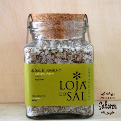 Frasco de vidro com sal e tomilho e etiqueta verde