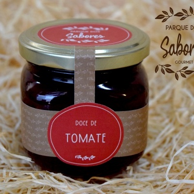 Frasco de doce de tomate com rótulo vermelho e bege sobre palha