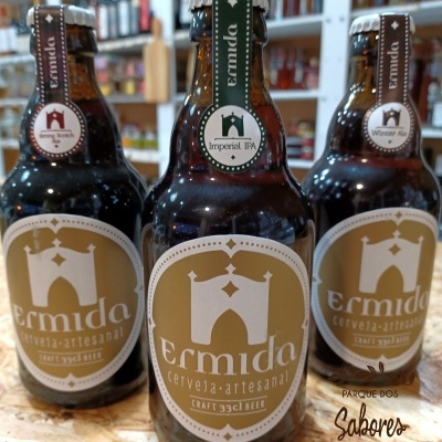 Três garrafas de cerveja artesanal Ermida com rótulos castanhos e bege