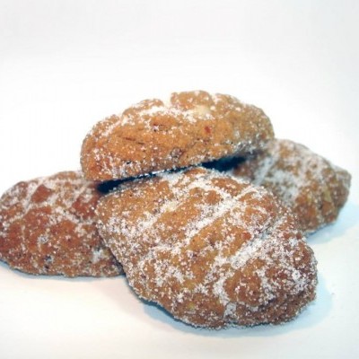 Quatro biscoitos amarelo-dourados cobertos com açúcar, em fundo branco