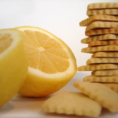 Limão cortado ao meio ao lado de bolachas empilhadas sobre fundo branco