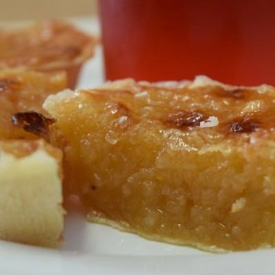 Tarte de massa folhada cortada ao meio com copo vermelho ao fundo