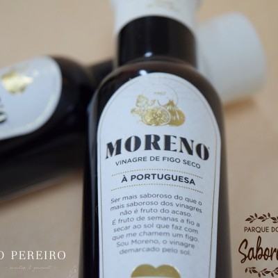 Garrafa de vinagre de figo seco Moreno com rótulo branco e preto, ao lado de embalagem de cartão e outra garrafa.