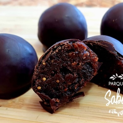 Bolas de chocolate com interior visível, em fundo de madeira clara