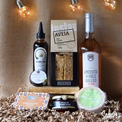 Produtos gourmet variados embalados e organizados sobre fundo rústico com luzes amareladas