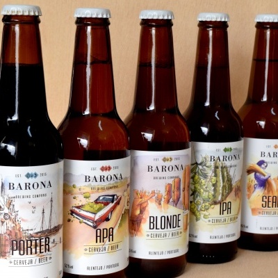Cinco garrafas de cerveja Barona com rótulos coloridos diferentes alinhadas