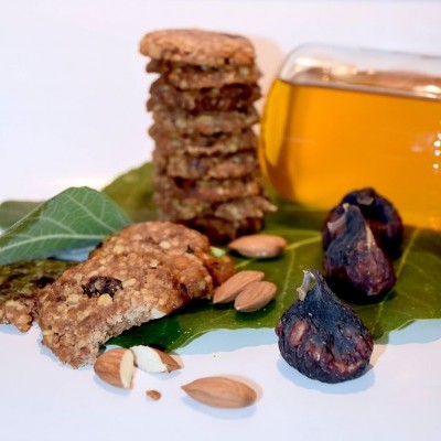 Bolachas de aveia com passas, amêndoas, figos secos e mel sobre folhas verdes