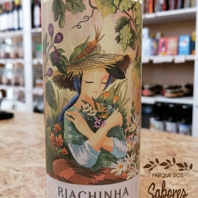 Garrafa de vinho branco com rótulo ilustrado de mulher com chapéu de palha e flores