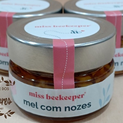 Frascos pequenos de mel com nozes com tampa metálica e rótulo branco e rosa