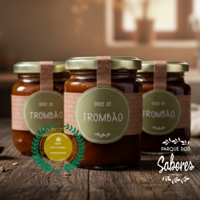 Frascos de doce de trombão com etiquetas verdes e faixas rosa sobre mesa de madeira