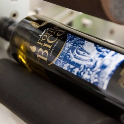 Garrafa de vidro verde escuro com rótulo preto e azul