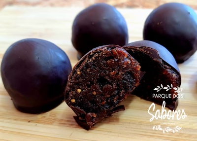 Bolas de chocolate com interior visível, em fundo de madeira clara