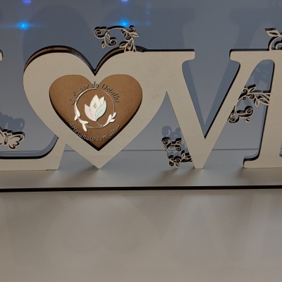 Escultura decorativa em madeira com palavra LOVE e detalhes florais e borboletas