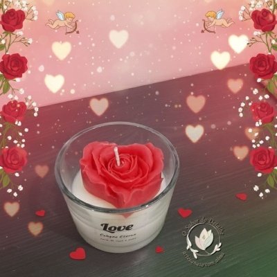 Vela em copo de vidro com rosa vermelha decorativa, fundo rosa decorado com rosas e corações