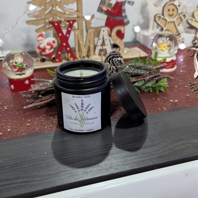Vela da Harmonia lavanda em frasco preto com decoração natalícia ao fundo