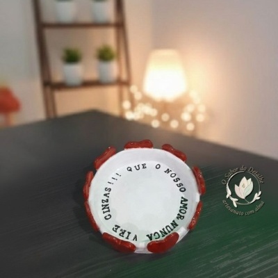 Cinzeiro redondo em cerâmica branco com detalhes vermelhos e texto em preto no interior