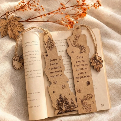 Marcadores de páginas em papel kraft com desenhos e texto em português sobre livro aberto