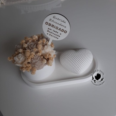 Arranjo decorativo com flores artificiais brancas e bege, coração texturizado branco, cartão agradecimento, sobre bandeja branca.
