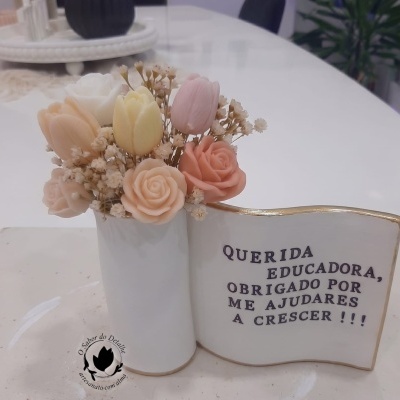 vaso com flores artificiais em tons pastel e placa decorativa com agradecimento a educadora