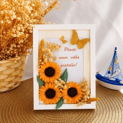Quadro decorativo com girassóis, flores secas, texto em português e borboletas amarelas