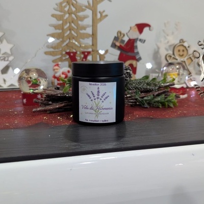 Vela da Harmonia em frasco preto com decoração natalícia ao fundo