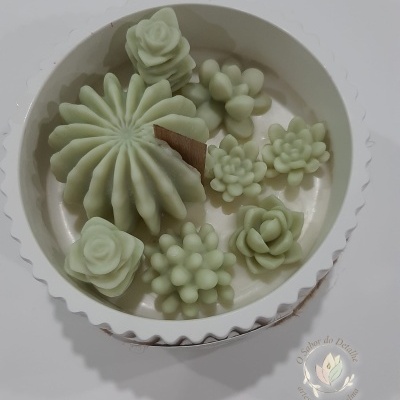 Conjunto de velas decorativas em formato de flores e suculentas verdes claras numa caixa branca
