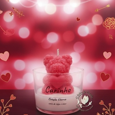 Vela decorativa com urso cor de rosa em copo de vidro e fundo vermelho