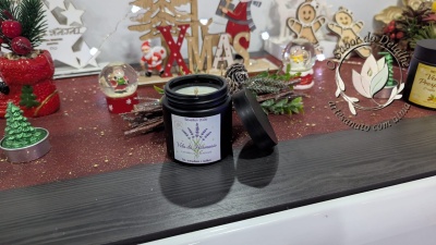 Vela da Harmonia lavanda em frasco preto com decoração natalícia ao fundo