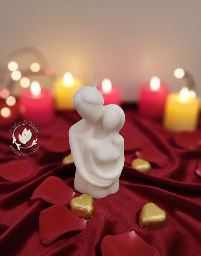 Vela branca em forma de casal abraçado com decoração romântica