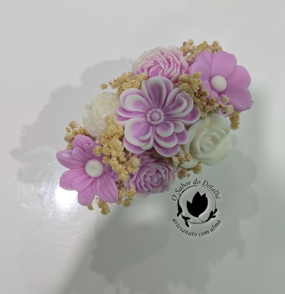 Arranjo de flores decorativas lilás e branco com raminhos secos sobre fundo branco