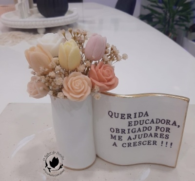 vaso com flores artificiais em tons pastel e placa decorativa com agradecimento a educadora